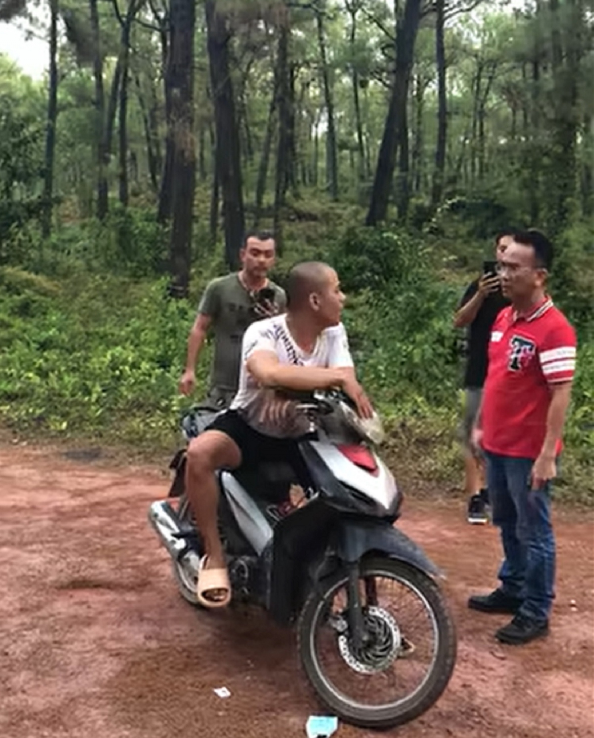 Thanh niên thản nhiên ngồi trên xe máy thách thức người dân gọi công an đến bắt