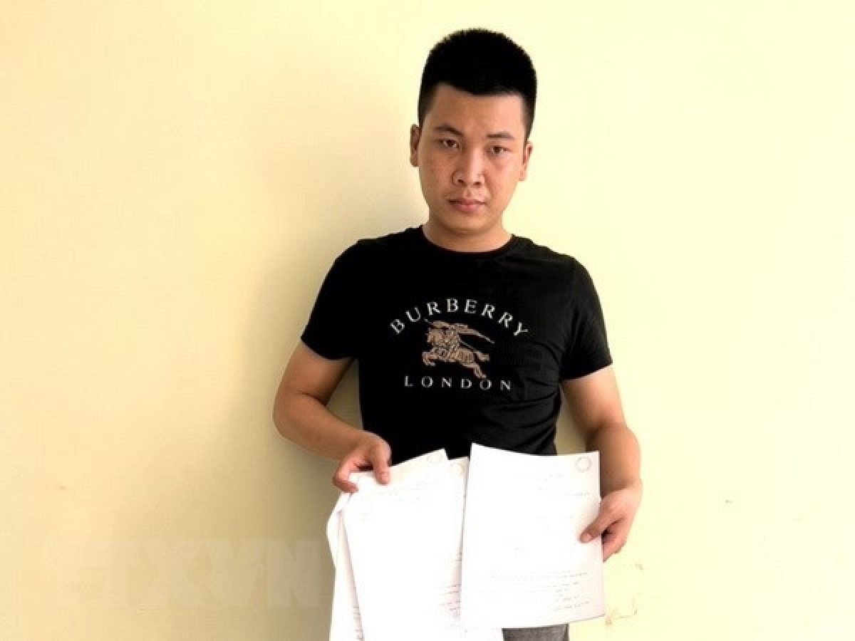 Đối tượng Đinh Văn Trường cùng tang vật vụ việc. (Ảnh: TTXVN phát)