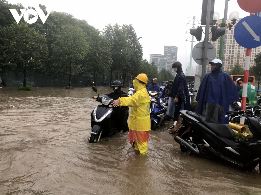 Workers of the Hanoi Sewerage and Drainage Company have been fanned out to flooded areas to regulate traffic.