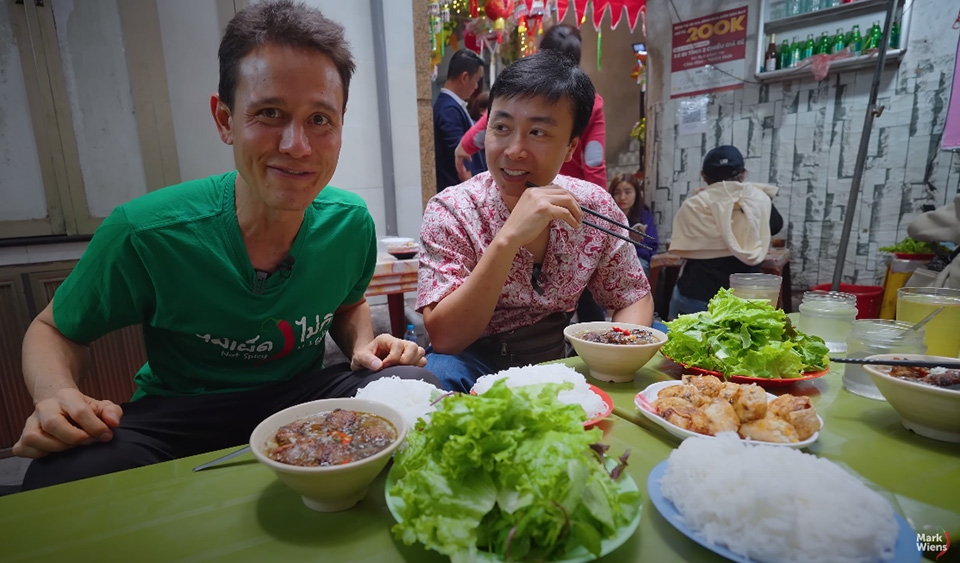 The vlogger try bún chả with his Vietnamese friend