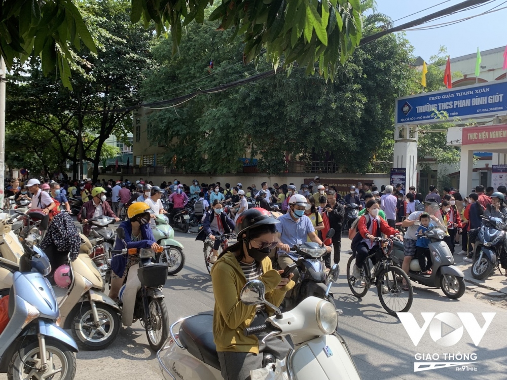 Phụ huynh chờ đón con trước cổng trường THCS Phan Đình Giót. Ảnh: Thái Sơn