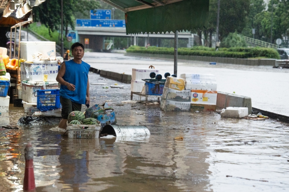 Nước lũ dâng lên nhấn chìm sạp hàng của một tiểu thương bán hoa quả bên đường ở Hong Kong. Ảnh: Reuters