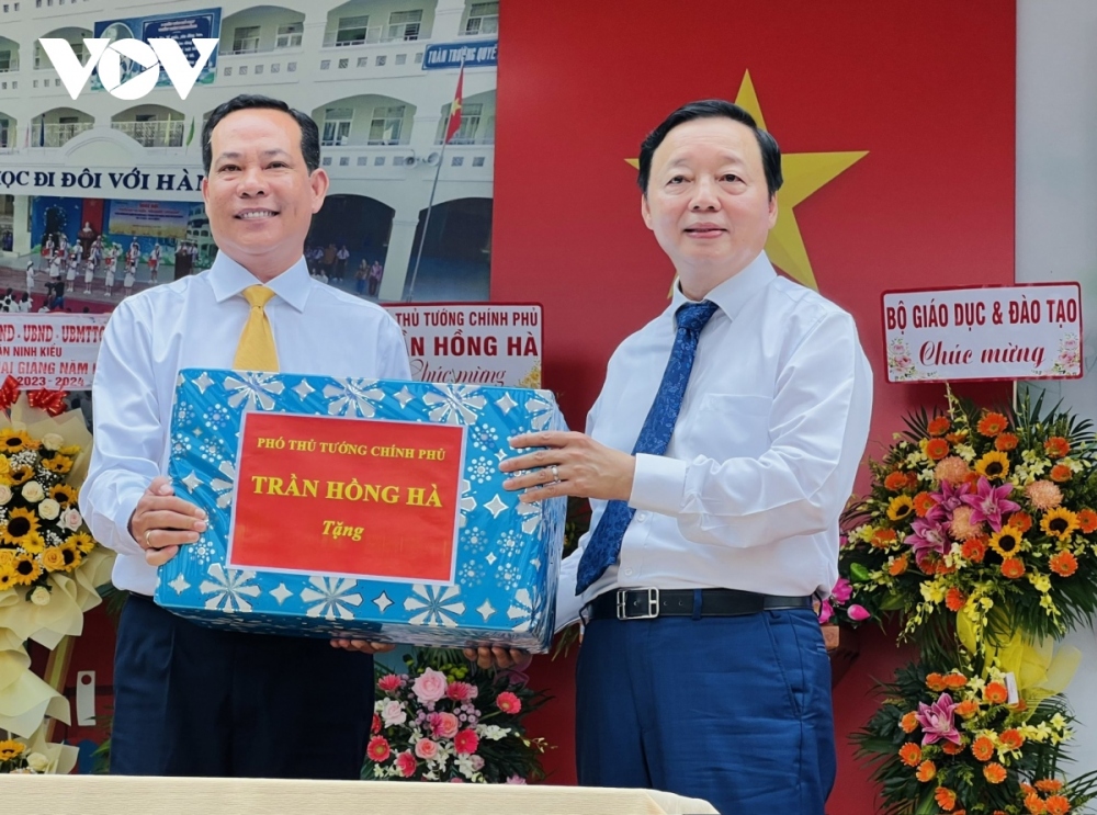 Deputy Prime Minister Tran Hong Ha (R) hands over a gift aimed at encouraging both teachers and students at Doan Thi Diem secondary school in Ninh Kieu district of Can Tho city ahead of the new academic year.