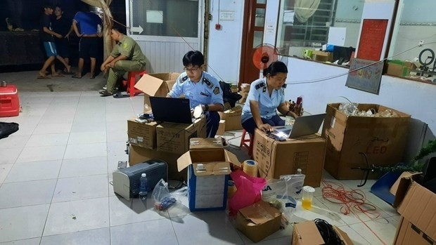 Đội Quản lý thị trường số 1 tiến hành kiểm kê, lập biên bản vi phạm các sản phẩm điện tử không rõ nguồn gốc. (Ảnh: TTXVN)
