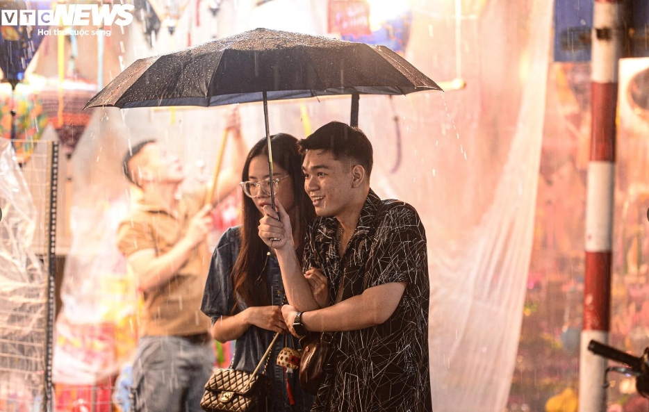 Các gia đình, bạn trẻ vội mang áo mưa, cầm ô để tìm chỗ trú.
