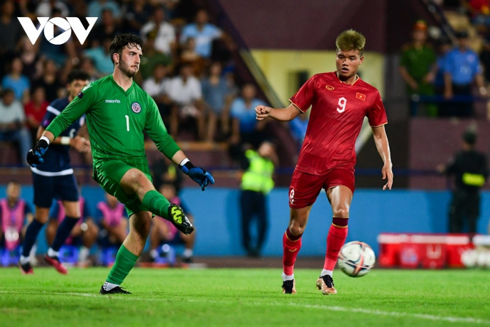 Van Tung (in red jersey) beats the Guam goalkeeper, extending Vietnam's lead in the second half