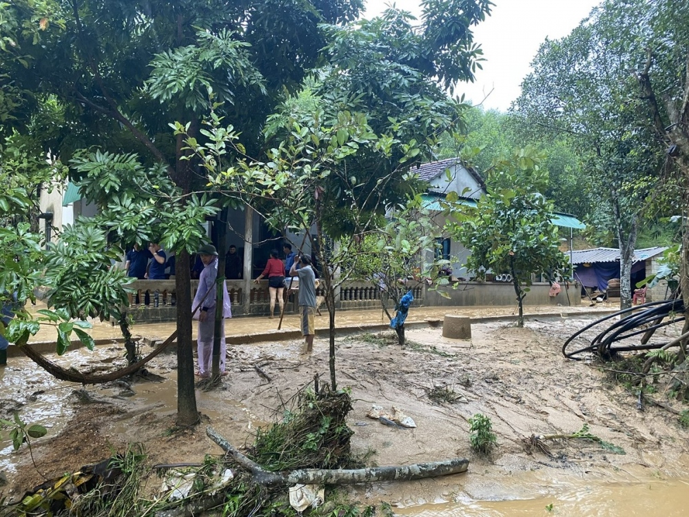 Ngành chức năng phối hợp với người dân địa phương đến hỗ trợ gia đình bị lũ ống dọn dẹp nhà cửa