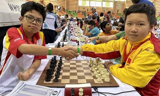 Dau Khuong Duy (left) and Nguyen Nam Kiet shake hand before the final round match of the World Cadet U8, U10, U12 Championships 2023. Duy wins the trophy of the U12 class. (VNS Photo Minh Thang)