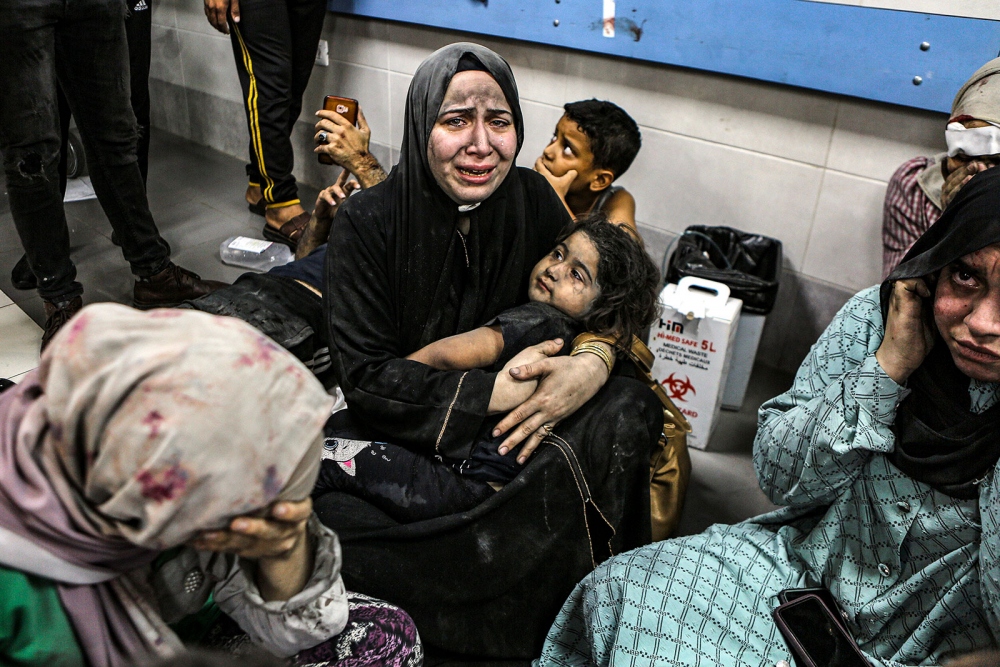 Những người Palestine bị thương ngồi trên sàn tại Bệnh viện Al-Shifa sau khi được vận chuyển từ Bệnh viện Baptist Al-Ahli, nơi hàng trăm người thiệt mạng sau vụ không kích hôm 17/10 (Ảnh: Reuters)