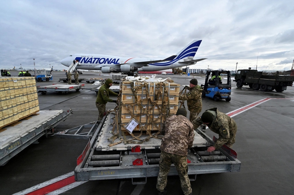 Binh sĩ Ukraine bốc dỡ hàng viện trợ của Mỹ tại sân bay Kiev năm 2022 (Ảnh: AFP).