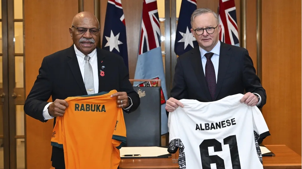 Thủ tướng Fiji Sitiveni Rabuka (trái) và Thủ tướng Australia Anthony Albanese (phải) trao đổi áo chơi bóng bầu dục sau cuộc hội đàm tại Quốc hội. Nguồn AAP