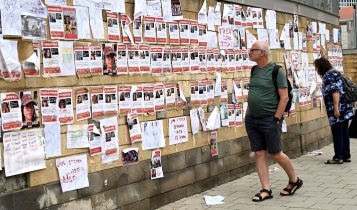 Người dân ở Tel Aviv, Israel nhìn những tấm áp phích in hình người Israel bị Hamas bắt làm con tin. Ảnh: Shutterstock