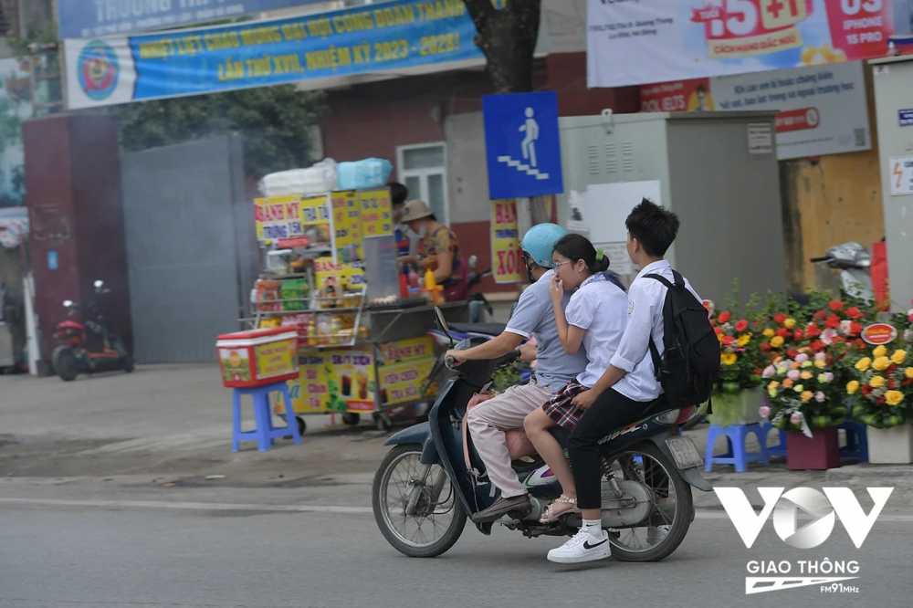 Không khó để bắt gặp các bậc phụ huynh cũng ''quên'' phải đội mũ bảo hiểm khi đưa con em mình đi học