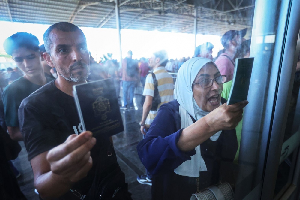 Người Palestine có hai quốc tịch xuất trình hộ chiếu khi xin rời Gaza tại cửa khẩu Rafah vào Ai Cập, ngày 1/11.
