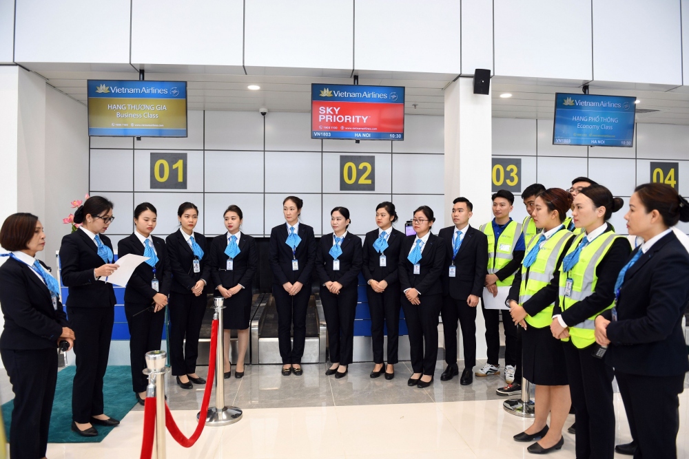 Các nhân viên phục vụ mặt đất họp trao đổi nhanh công tác chuẩn bị quầy làm thủ tục theo kế hoạch chuyến bay