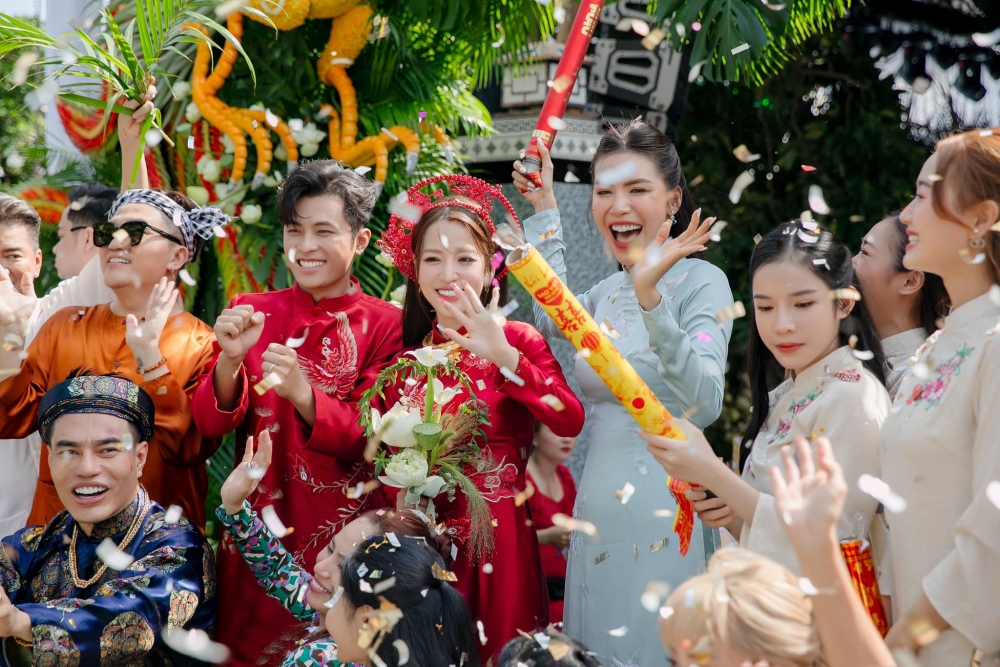 Minh Tú (áo dài xanh) làm phụ dâu. Ở tiệc cưới của cặp sao tại Cam Ranh hôm 4/11, cô bắt được hoa của cô dâu, được đồng nghiệp chúc sớm tổ chức lễ cưới cùng bạn trai người Đức.