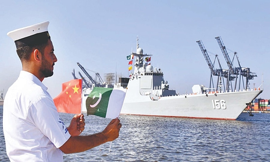 Một thủy thủ vẫy cờ Trung Quốc và Pakistan tại một cảng của hải quân Pakistan. Ảnh: PPI.