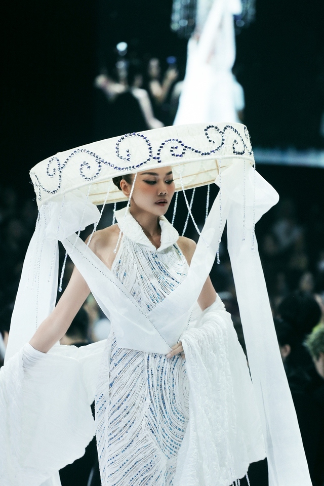 Model Thanh Hang impresses audiences by donning a nón quai thao, a traditional Vietnamese flat palm hat.