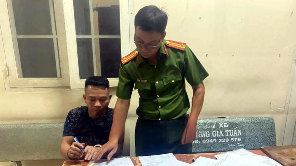 Đối tượng Trần Đức Hữu ký các biên bản tịch thu tang vật - Ảnh: CACC