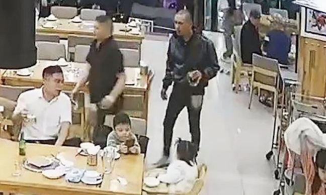 Anh T. ngồi trong nhà hàng cùng các con trước khi bị đánh. (Ảnh cắt từ clip)