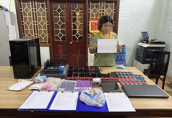 Đối tượng H.T.B.V trú tại thành phố Quy Nhơn, tỉnh Bình Định - mắt xích quan trọng trong đường dây lừa đảo, cùng tang vật thu giữ được tại cơ quan điều tra. Ảnh: TTXVN phát