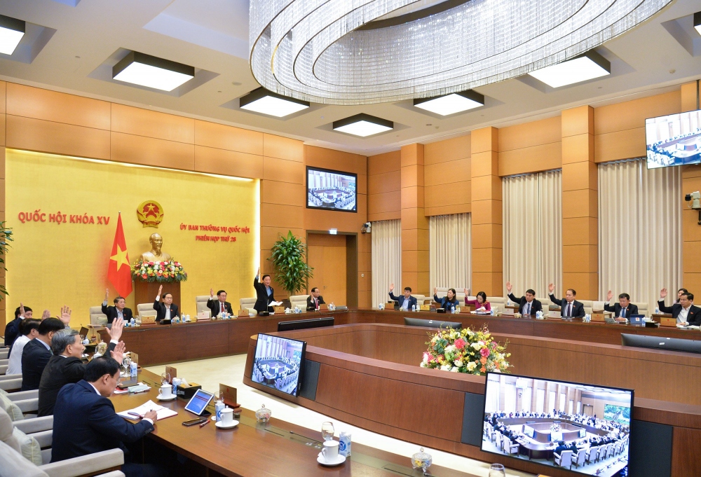 Các thành viên Ủy ban Thường vụ Quốc hội biểu quyết thông qua các nghị quyết trong phiên làm việc sáng 13/12