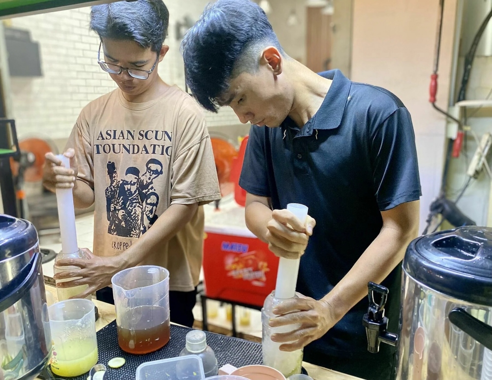 Trà chanh giã tay - một trong những "hot trend" khởi nghiệp gần đây. Ảnh: Nhân viên pha chế trà chanh giã tay ở cửa tiệm anh Thịnh, quận 1, TP HCM, tối 13/11 - Ngọc Ngân/VnExpress