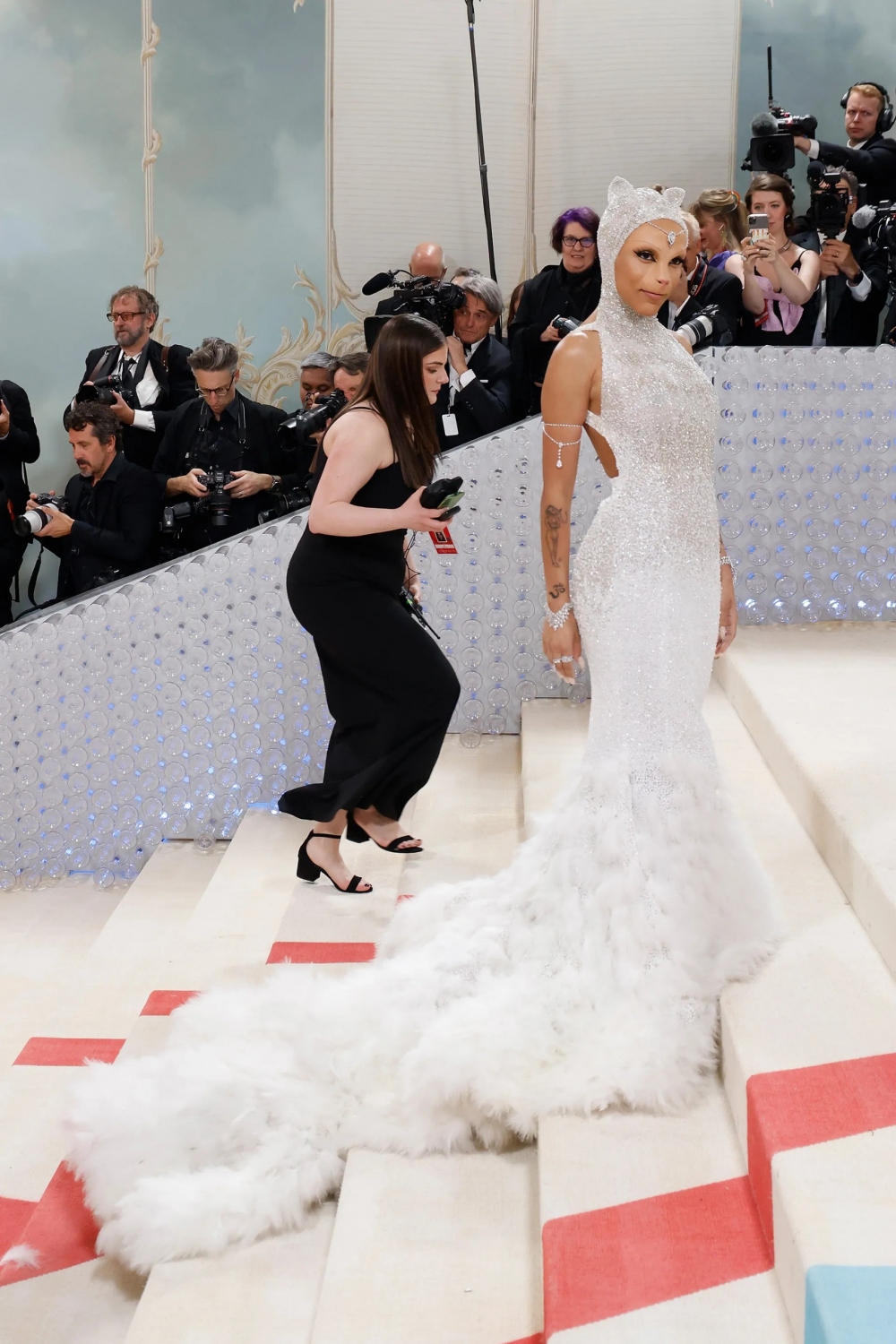 Mèo Doja trong vai chú mèo nạm kim cương tại Met Gala. Cảm hứng cho vẻ ngoài của Doja dường như đến từ The Aristocats ' Duchess. Trên thảm đỏ, Doja đội một chiếc mũ đội đầu có đính một viên kim cương cắt hình quả lê 17 cara, nhẫn và vòng tay bằng kim cương, cũng như một chiếc vòng tay bằng kim cương đặt làm riêng. Tất cả đều được thợ kim hoàn người Pháp Messika thiết kế riêng.