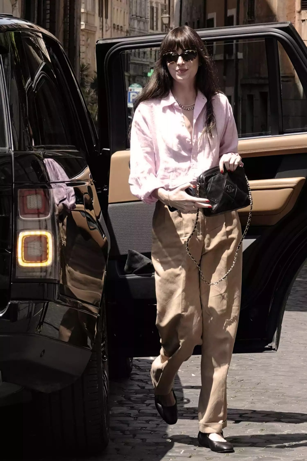 Một trong những phong cách đường phố nổi bật gần đây nhất của Dakota Johnson là sự theo đuổi của xu hướng thời trang Quiet Luxury. Nữ diễn viên kết hợp quần lửng màu nâu với áo sơ mi màu hồng nhạt và giày bệt màu đen tiện dụng, đồng thời kết hợp phụ kiện đơn giản như túi đeo chéo Chanel và kính râm đen.
