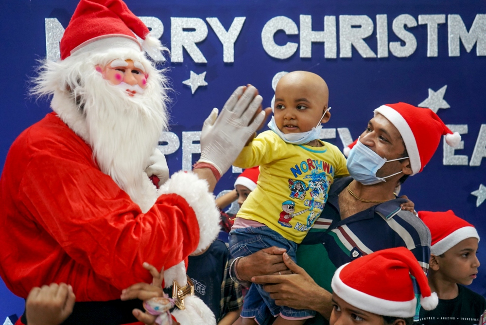 Một người trong trang phục ông già Noel giao lưu, trao quà cho trẻ em tại bệnh viện Nhi Bai Jerbai Wadia ở Mumbai ngày 23/12. Ảnh: ANI