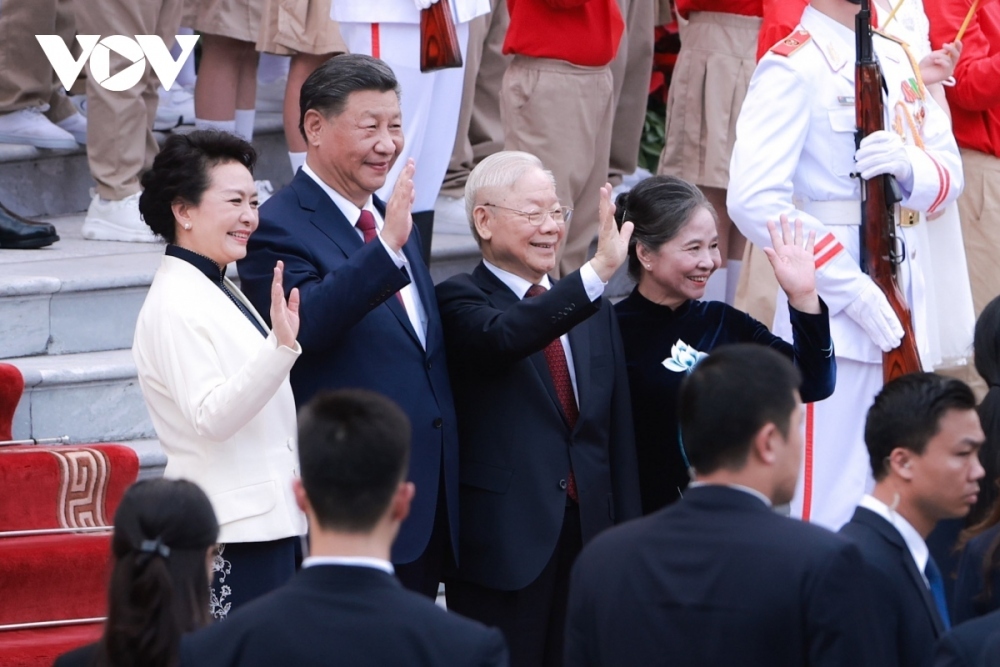 The two Party leaders and their wives wave at officials of both Vietnam and China at the welcoming ceremony.