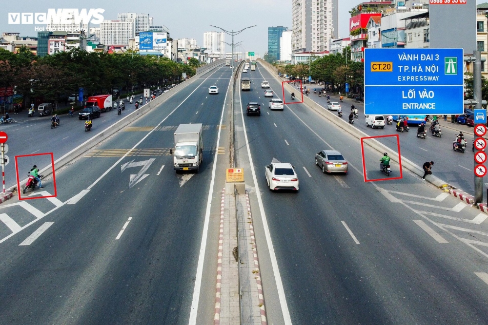 Trên đường cao tốc Vành đai 3 trên cao (đoạn cầu vượt Mai Dịch, Hà Nội), tình trạng xe khách dừng đỗ sai quy định để đón trả khách, xe ôm và người đi bộ bất chấp nguy hiểm đi vào đường cấm thường xuyên xảy ra.