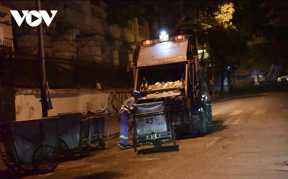 Sanitation workers struggle in the chilly coldness as they clean the road.