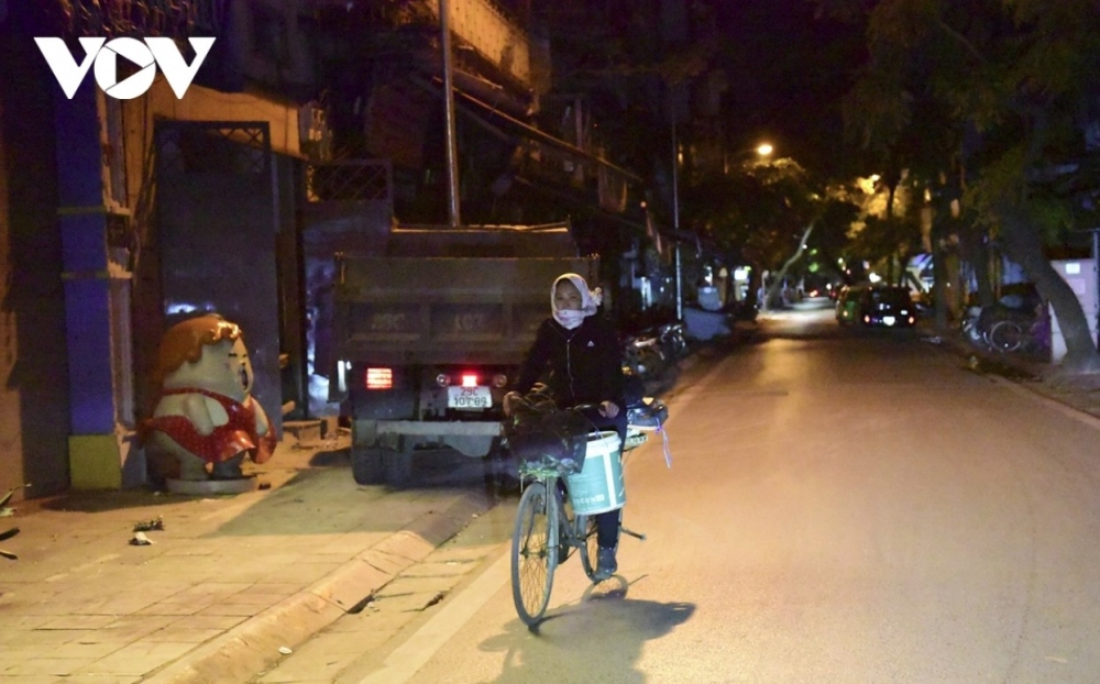 A woman wonders along Hanoi’s streets collecting rubbish to earn a living.