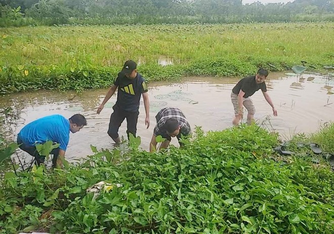 Lực lượng chức năng mò tìm tang vật vụ án tại mương nước nơi hủy chứng cứ vụ án.