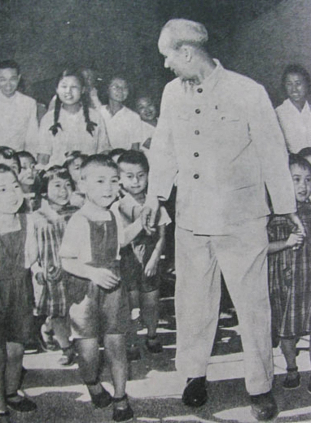 Chủ tịch Hồ Chí Minh dắt tay một em bé trong chuyến thăm Trung Quốc.