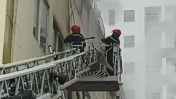Lực lượng chữa cháy đục tường cứu các nạn nhân mắc kẹt (ảnh: Thiên Lý)