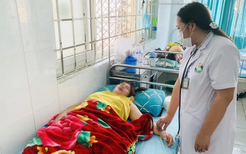 Bác sỹ của một trung tâm Y tế huyện thăm khám cho các bệnh nhân bị ngộ độc sau khi đi ăn đám cưới. (Ảnh: TTXVN)