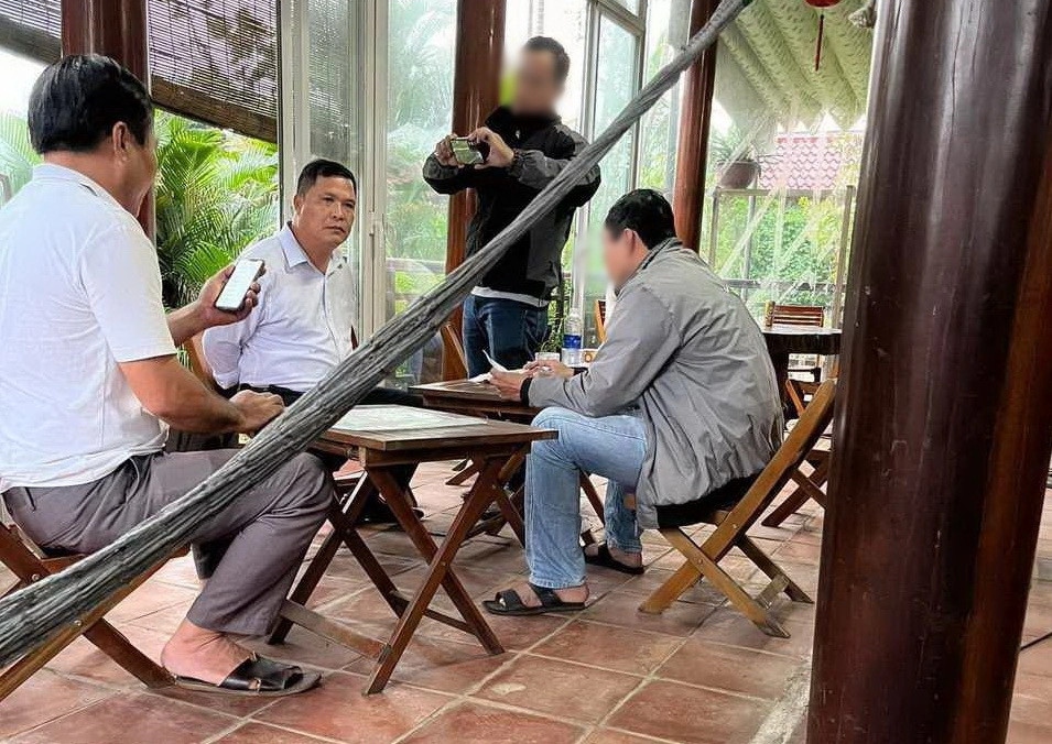 Đặng Ngọc Bảo (thứ 2 từ trái sang) bị lực lượng công an bắt quả tang khi đang nhận 9,8 triệu đồng