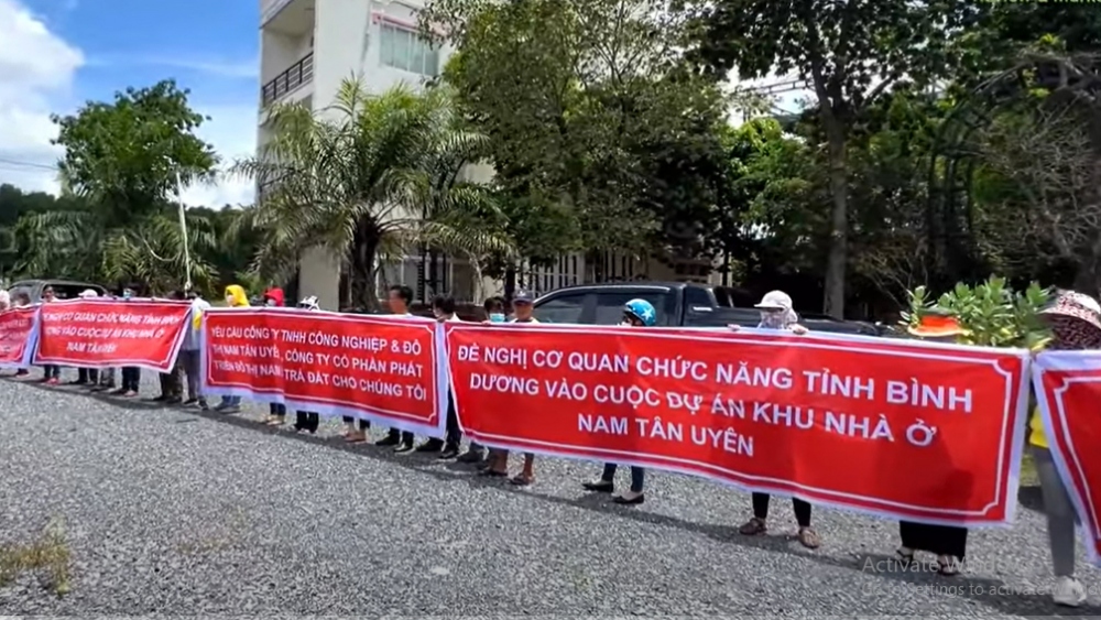 Khách hàng căng băng rôn yêu cầu chủ đầu tư giao đất - Ảnh: MXH
