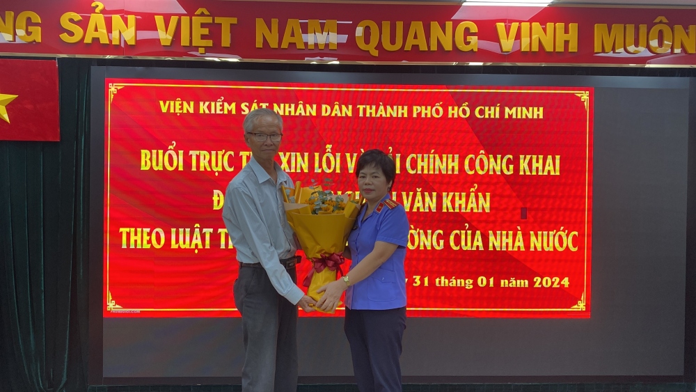 Đại diện Viện kiểm sát nhân dân TP.HCM xin lỗi công khai và tặng hoa ông Nguyễn Văn Khẩn. Ảnh: T.M