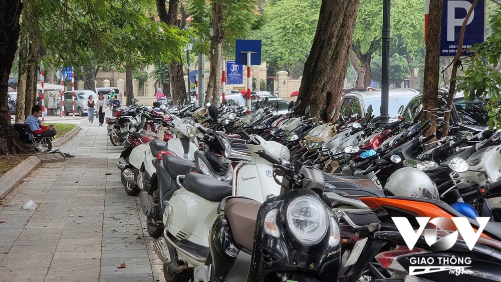 Một bãi gửi xe tại khu vực vườn hoa Lý Thái Tổ chỉ được cấp phép trông giữ ô tô nhưng lại nhận trông giữ xe máy, chiếm dụng vỉa hè của người đi bộ