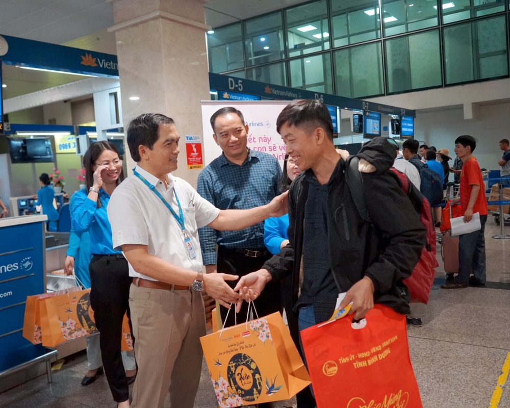 Đại diện Vietnam Airlines tặng quà hành khách chuyến bay mang số hiệu VN218 của chở người lao động có hoàn cảnh khó khăn về quê ăn Tết hành trình TP HCM - Hà Nội ngày 29/1/2024.