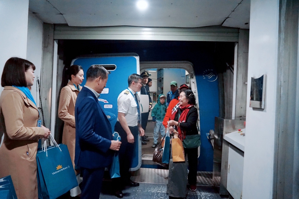 Đại diện Vietnam Airlines tặng quà hành khách chuyến bay mang số hiệu VN218 của chở người lao động có hoàn cảnh khó khăn về quê ăn Tết.