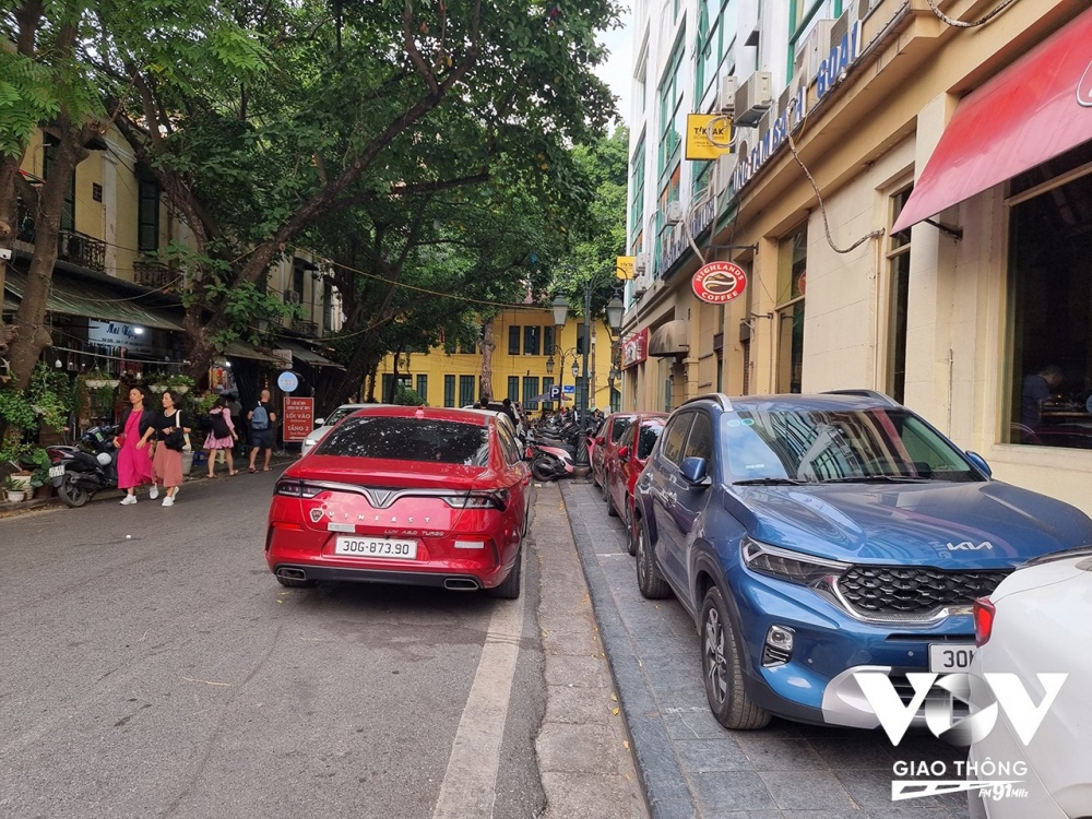 Bãi trông giữ xe tại phố Nguyễn Xí (Hoàn Kiếm, Hà Nội) nhận trông cả ô tô và xe máy chiếm dụng hoàn toàn vỉa hè của người đi bộ