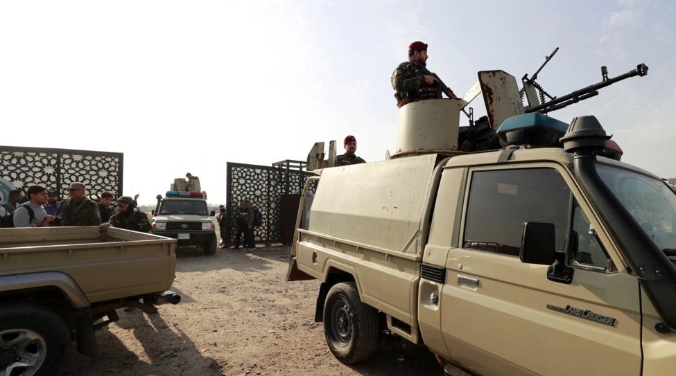 Các thành viên của một nhóm dân quân tại Iraq canh giữ lối vào trụ sở của họ ở thủ đô Baghdad. Ảnh: AFP
