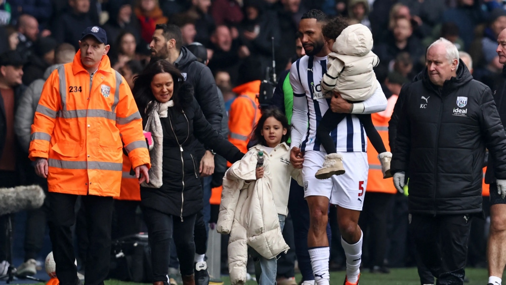 Hậu vệ Kyle Bartley đưa người nhà rời khỏi khán đài. (Ảnh: Getty)
