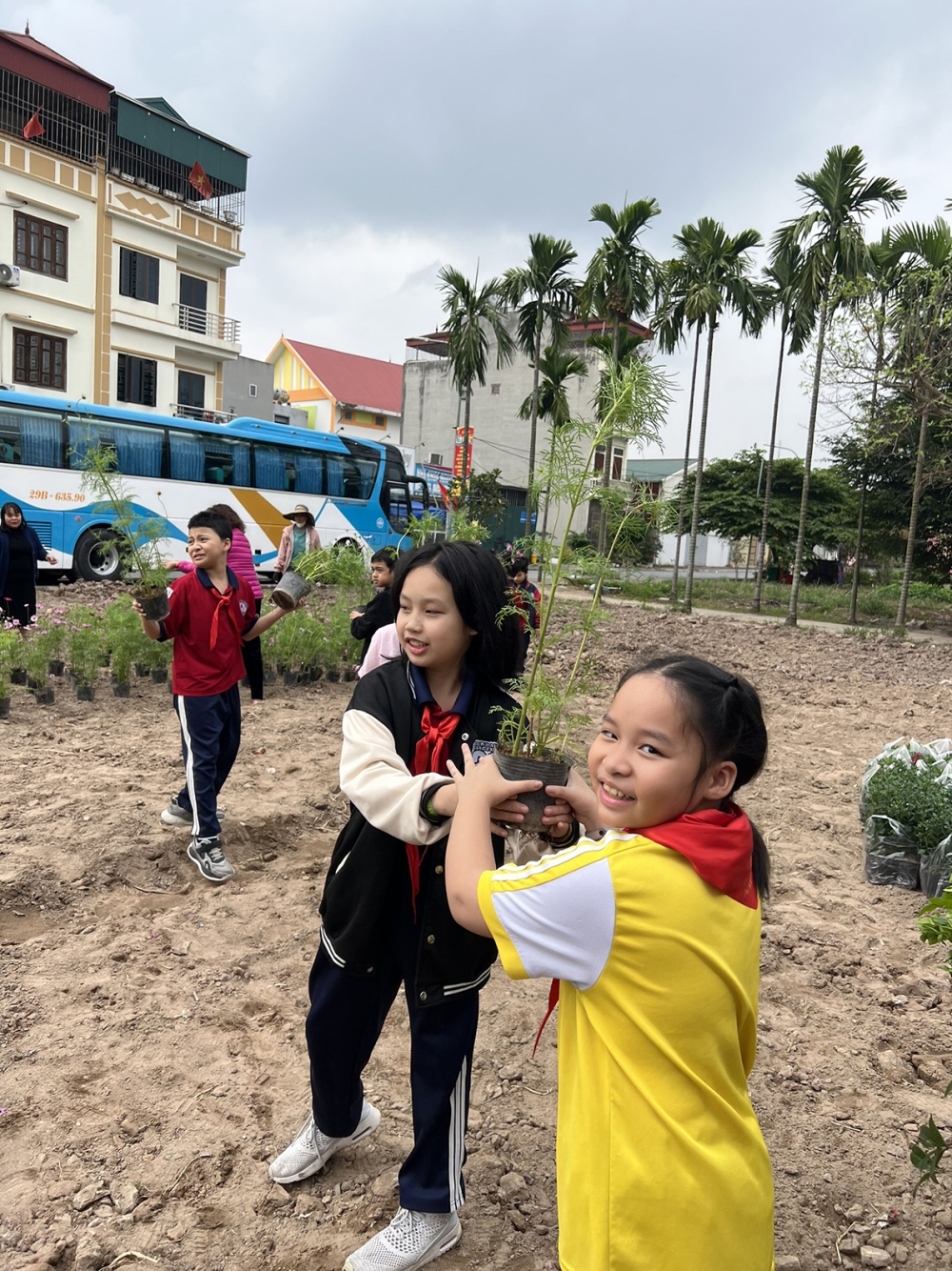 Các em học sinh hào hứng lao động ở bãi đất đã được làm sạch cỏ.