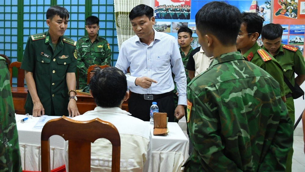 Đại tá Lê Văn Vỹ, Chỉ huy trưởng Bộ đội Biên phòng tỉnh Tây Ninh (áo trắng) làm việc với đối tượng (ảnh Quân Lê)