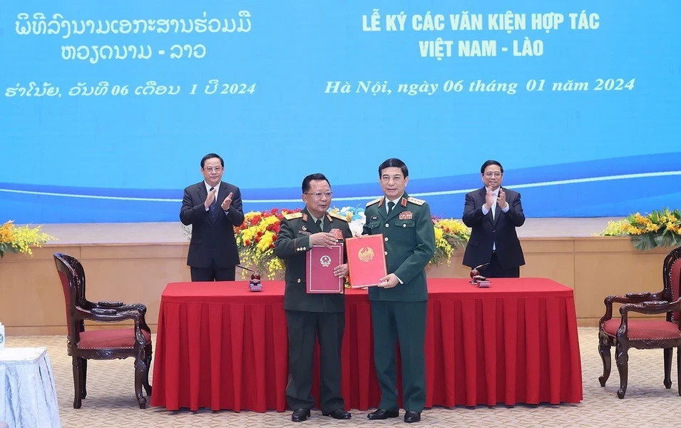 Đại tướng Phan Văn Giang, Bộ trưởng Bộ Quốc phòng Việt Nam và Đại tướng Chansamone Chanyalath, Phó Thủ tướng, Bộ trưởng Bộ Quốc phòng Lào ký Nghị định thư hợp tác biên phòng giữa hai Bộ Quốc phòng. (Ảnh: TTXVN)